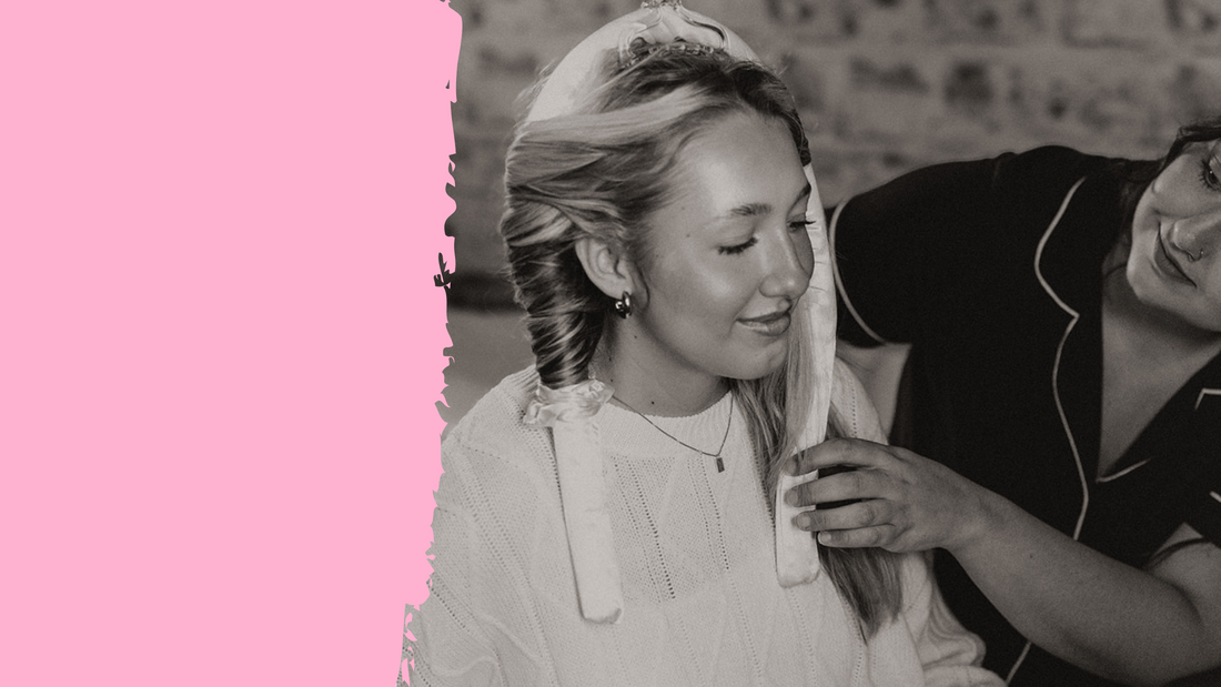 Woman wearing satin heatless curlers being styled by a friend, showcasing a no-heat curling method in a cozy, casual setting.