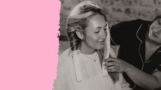 Woman wearing satin heatless curlers being styled by a friend, showcasing a no-heat curling method in a cozy, casual setting.